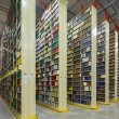 Rows of very tall, large bookshelves (stacks) in a warehouse