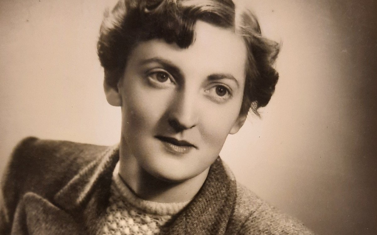 A sepia portrait of a women with short hair, wearing a jumper and a blazer over the top,