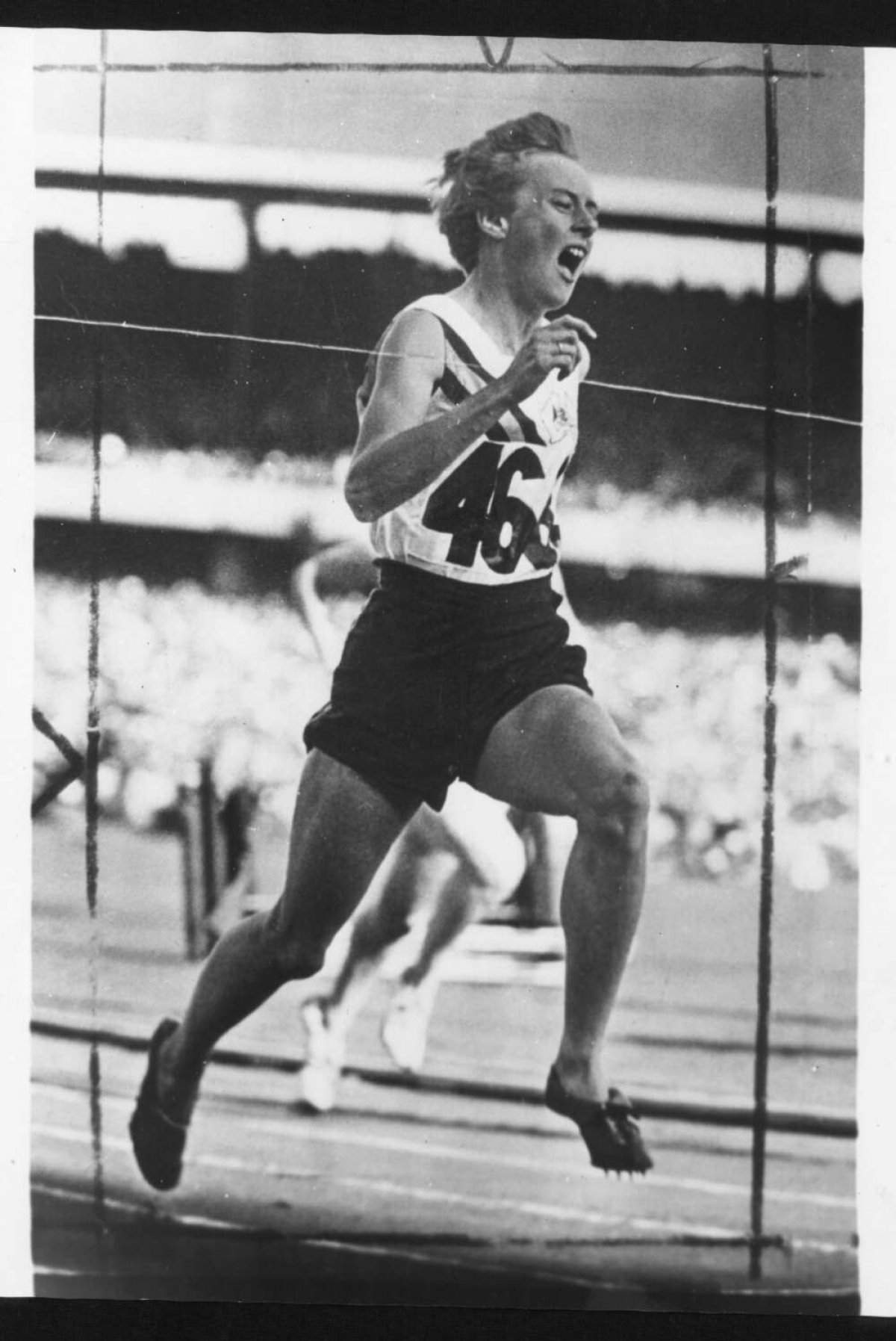 A black and white photo of Betty Cuthbert running on the track.