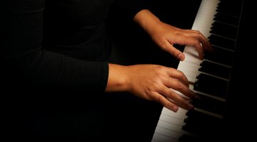 Top down view of hands at a piano