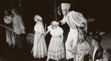 A group of people perform on stage in costume