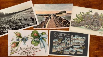 Five postcards with varied imagery on a wooden surface.