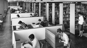 Students in desks and browsing library shelves in Monash University Library