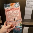 agery and text reading 'Thursdays at Orange Blossom House' and 'Sophie Green' being held up in front of a book display.