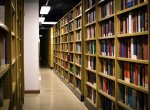 Tall bookshelves line the walls of a long corridor