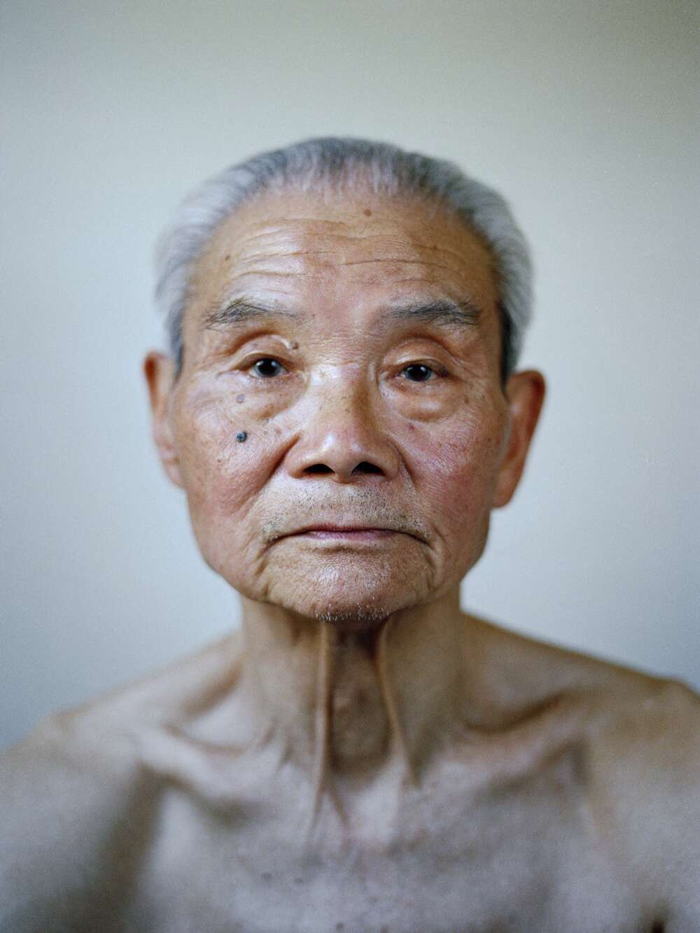 A close-up of an elderly man looking directly into the camera