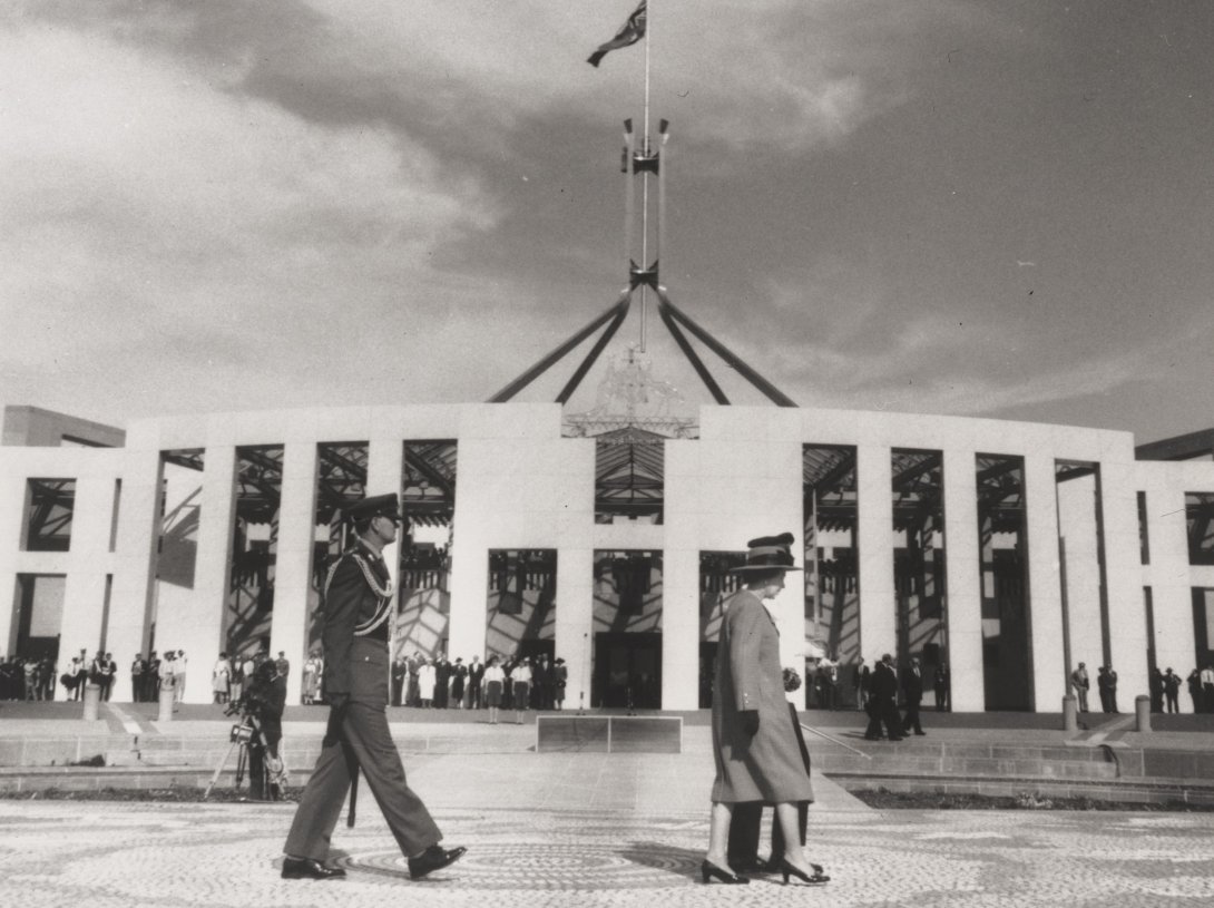 A black and white image of the Queen and Prince Philip walking out the front of Parliament House in Canberra.