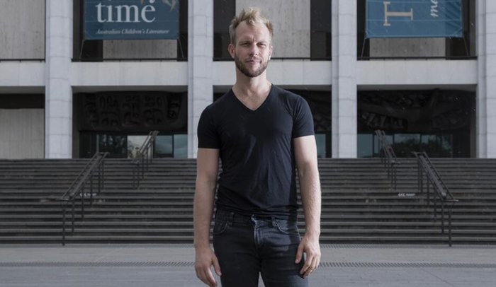 Photo of choreographer Joel Bray in front of the National Library of Australia.