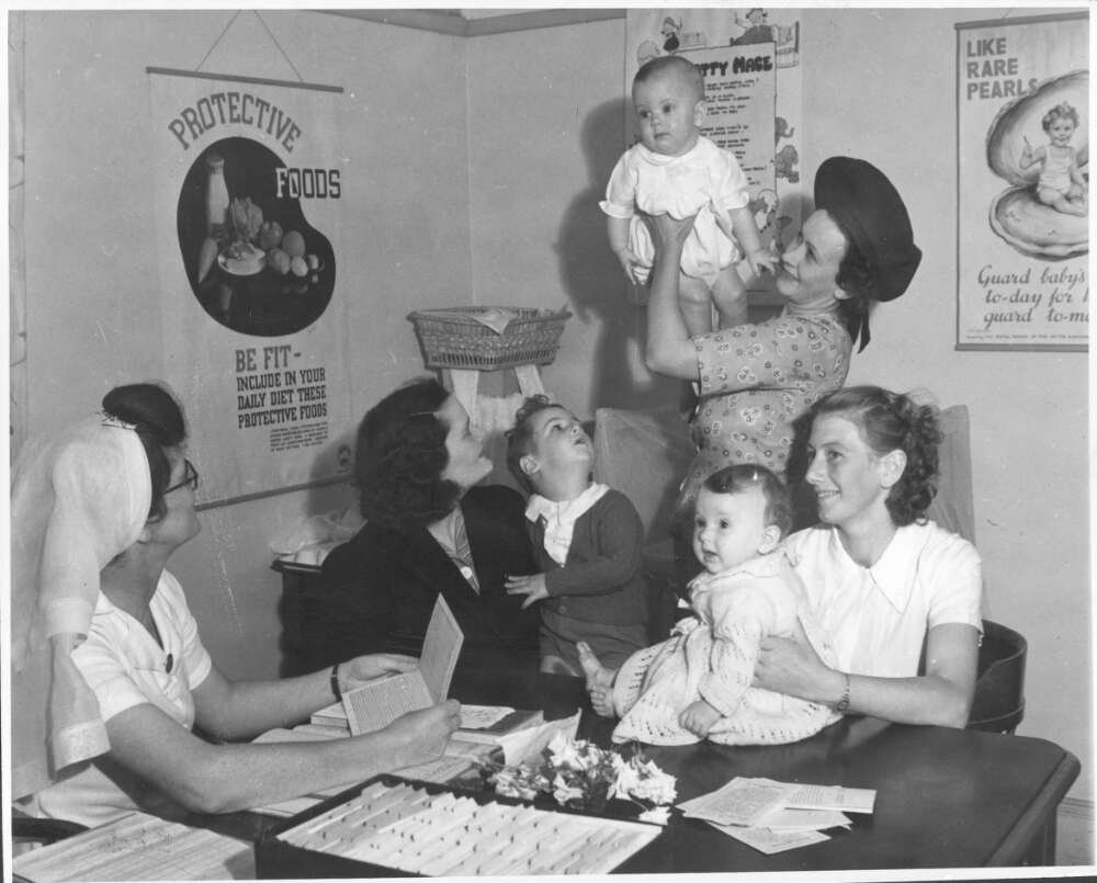 Three mothers with their babies chatting with a nurse at an infant welfare centre in the 1940s