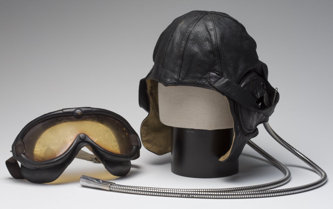 Old pilot's goggles and a leather pilot's cap with metal tubes coming from the back