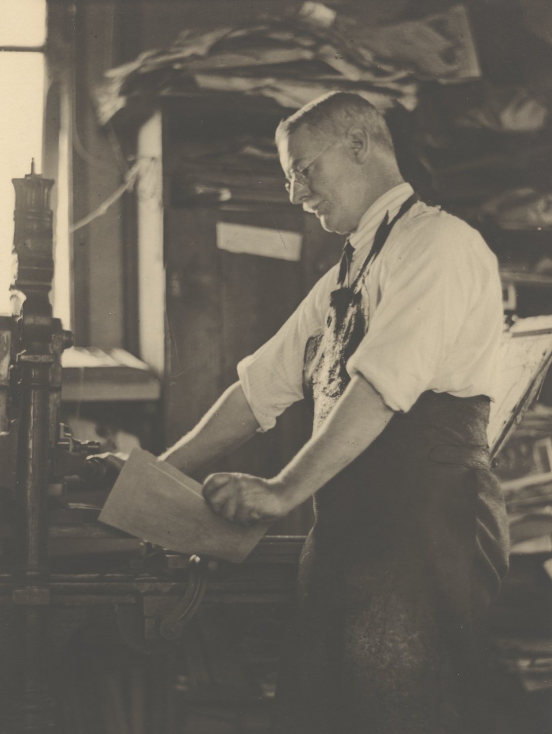 Sepia-toned photo of artist Lionel Lindsay at work in his studio